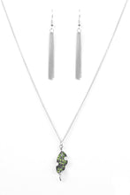 Load image into Gallery viewer, Attached to an elegantly elongated chain, a silver leaf pendant swings from the bottom of the slimming palette. Embossed in lifelike textures, the leafy pendant is encrusted in dazzling green rhinestones for a timeless finish. Features an adjustable clasp closure.  Sold as one individual necklace. Include one pair of matching earrings.