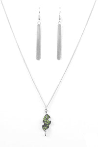 Attached to an elegantly elongated chain, a silver leaf pendant swings from the bottom of the slimming palette. Embossed in lifelike textures, the leafy pendant is encrusted in dazzling green rhinestones for a timeless finish. Features an adjustable clasp closure.  Sold as one individual necklace. Include one pair of matching earrings.