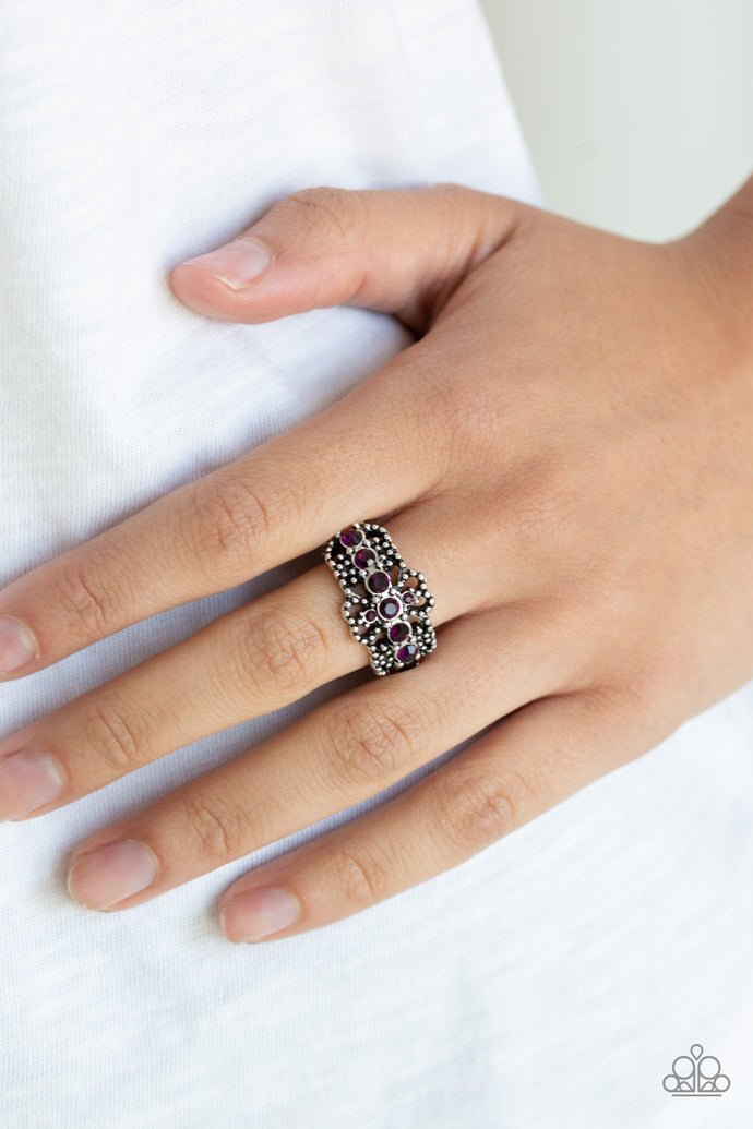Dotted silver filigree coalesces into an ornate band. The center of the frilly frame is encrusted in a glittery row of purple rhinestones for a refined finish. Features a dainty stretchy band for a flexible fit.  Sold as one individual ring.  Always nickel and lead free.