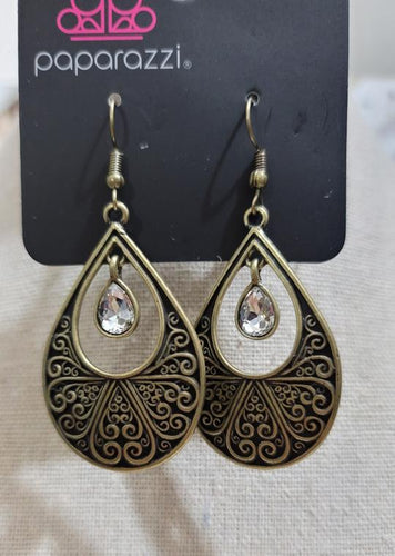 A white rhinestone swings from the top of a brass teardrop frame radiating with filigree textures for a refined look. Earring attaches to a standard fishhook fitting.  Sold as one pair of earrings.  Always nickel and lead free.  Fashion Fix January 2021