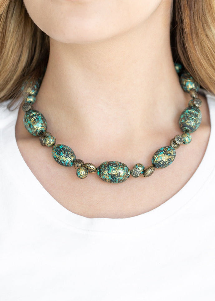 Featuring a brassy patina finish, a collection of ornate beads and an array of floral stamped brass beads are threaded along a brass wire below the collar for a seasonal flair. Features an adjustable clasp closure.  Sold as one individual necklace. Includes one pair of matching earrings.  Always nickel and lead free.