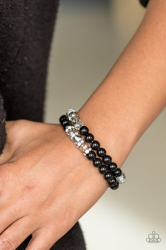 Faceted crystal-like beads and shiny black beads are threaded along stretchy elastic strands, creating radiant layers across the wrist. Encrusted in dazzling white rhinestones, dainty silver rings are sprinkled between one row of crystal-like beads for a refined finish.  Sold as one set of two bracelets.  Always nickel and lead free.