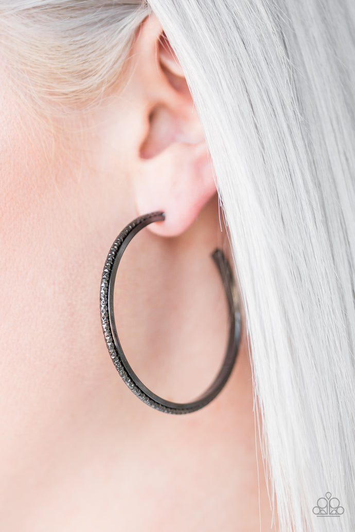 Etched in diamond cut textures, a shimmery gunmetal hoop curls around a smooth gunmetal frame, coalescing into an edgy hoop. Earring attaches to a standard post fitting. Hoop measures 2