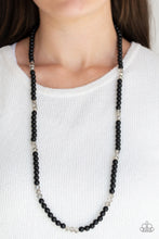 Load image into Gallery viewer, Infused with sections of smoky crystal-like beads, a timeless collection of black beads are threaded along an invisible wire across the chest for a refined flair. Features an adjustable clasp closure.  Sold as one individual necklace. Includes one pair of matching earrings.  