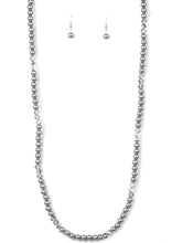 Load image into Gallery viewer, Infused with sections of smoky crystal-like beads, a timeless collection of silver pearls are threaded along an invisible wire across the chest for a refined flair. Features an adjustable clasp closure.  Sold as one individual necklace. Includes one pair of matching earrings.