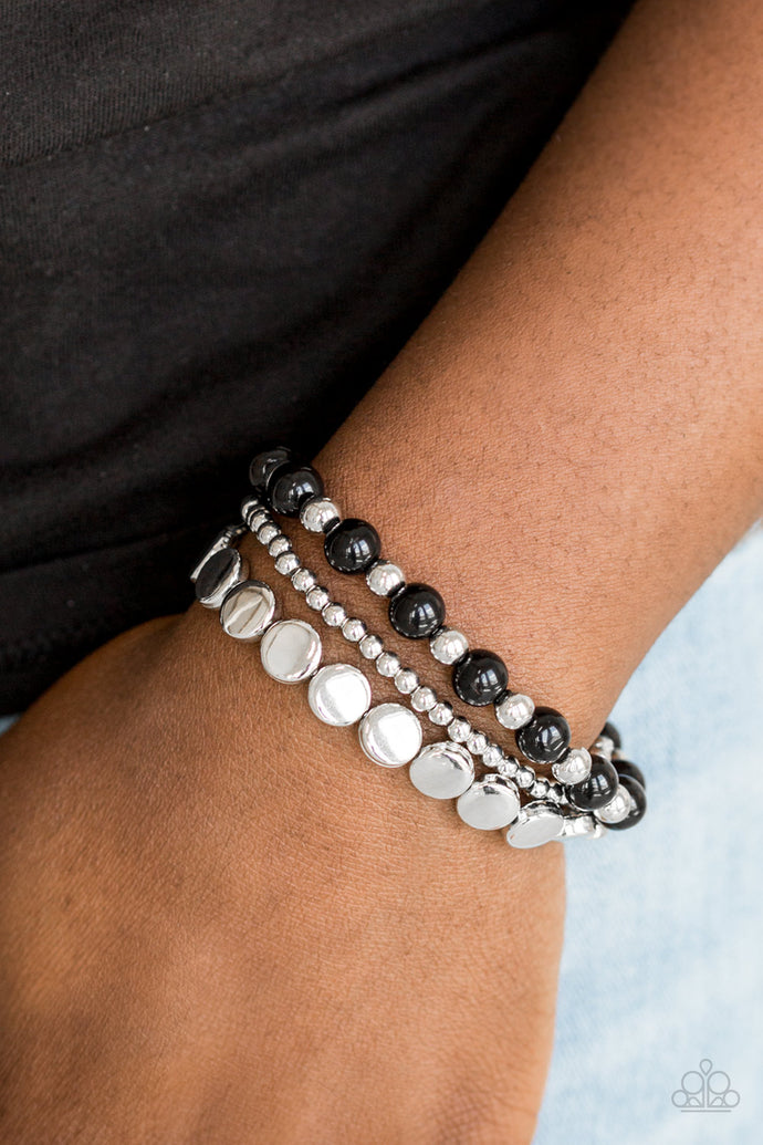 Mismatched silver and shiny black beads are threaded along stretchy elastic bands, creating colorful layers across the wrist.  Sold as one set of three bracelets. Always nickel and lead free.