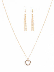 A glistening ribbon of gold curls into a romantic heart-shaped pendant below the collar. Glittery white rhinestones dust the inside of the whimsical frame, adding refined shimmer to the timeless palette. Features an adjustable clasp closure.  Sold as one individual necklace. Includes one pair of matching earrings.