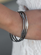 Load image into Gallery viewer, Delicately hammered in sections of shimmer, glistening gunmetal bangles stack across the wrist in a glamorous industrial fashion.  Sold as one set of three bracelets.