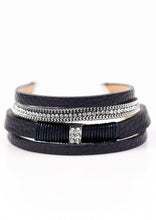 Load image into Gallery viewer, Brushed in a glistening finish, shimmery dark blue leather strands layer across the wrist in a colorful urban fashion. Strands of shimmery silver chain and dazzling white rhinestones adorn leather strands for a glamorous finish. Features an adjustable clasp closure.  Sold as one individual bracelet.