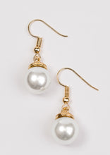 Load image into Gallery viewer, Capped in an ornate gold fitting, a solitaire white pearl swings from the ear in a timeless fashion. Earring attaches to a standard fishhook fitting.  Sold as one pair of earrings.