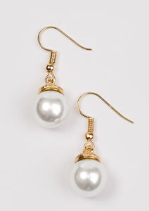 Capped in an ornate gold fitting, a solitaire white pearl swings from the ear in a timeless fashion. Earring attaches to a standard fishhook fitting.  Sold as one pair of earrings.