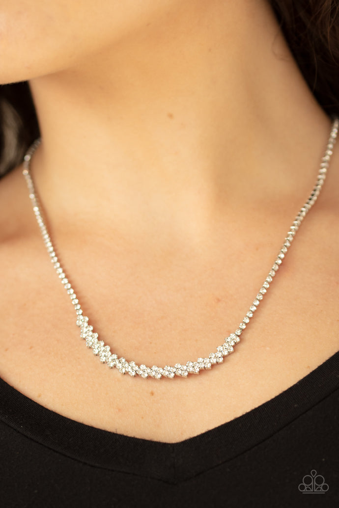 A dainty strand of glittery white rhinestones attach to a bowing pendant encrusted in blinding white rhinestones, creating a glitzy look below the collar. Features an adjustable clasp closure.  Sold as one individual necklace. Includes one pair of matching earrings.  Always nickel and lead free.