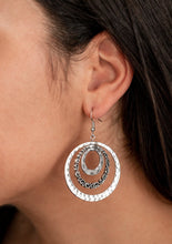 Load image into Gallery viewer, A rippling stack of hammered and filigree-filled silver hoops radiates from the ear, coalescing into a dizzying frame. Earring attaches to a standard fishhook fitting.