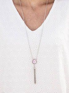 Featuring an opaque shimmer, a glassy pink gem is pressed into a sleek silver frame encrusted in dainty white rhinestones. The glowing pendant gives way to a glistening silver tassel for a whimsical finish. Features an adjustable clasp closure.  Sold as one individual necklace. Includes one pair of matching earrings.