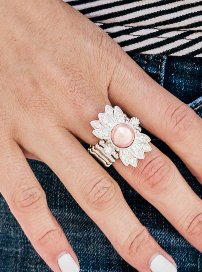 Dotted in glassy white rhinestones, shimmery silver frames flare out from the center of a pearly Blooming Dahlia bead, creating a regal centerpiece atop the finger. Features a stretchy band for a flexible fit.  Sold as one individual ring.    