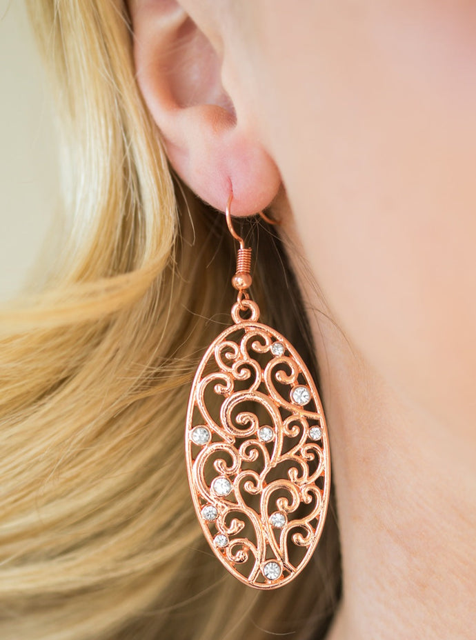 Vine-like filigree climbs a shiny copper oval frame. Dainty white rhinestones are sprinkled across the airy pattern, adding glassy splashes of shimmer to the whimsical palette. Earring attaches to a standard fishhook fitting.  Sold as one pair of earrings.  