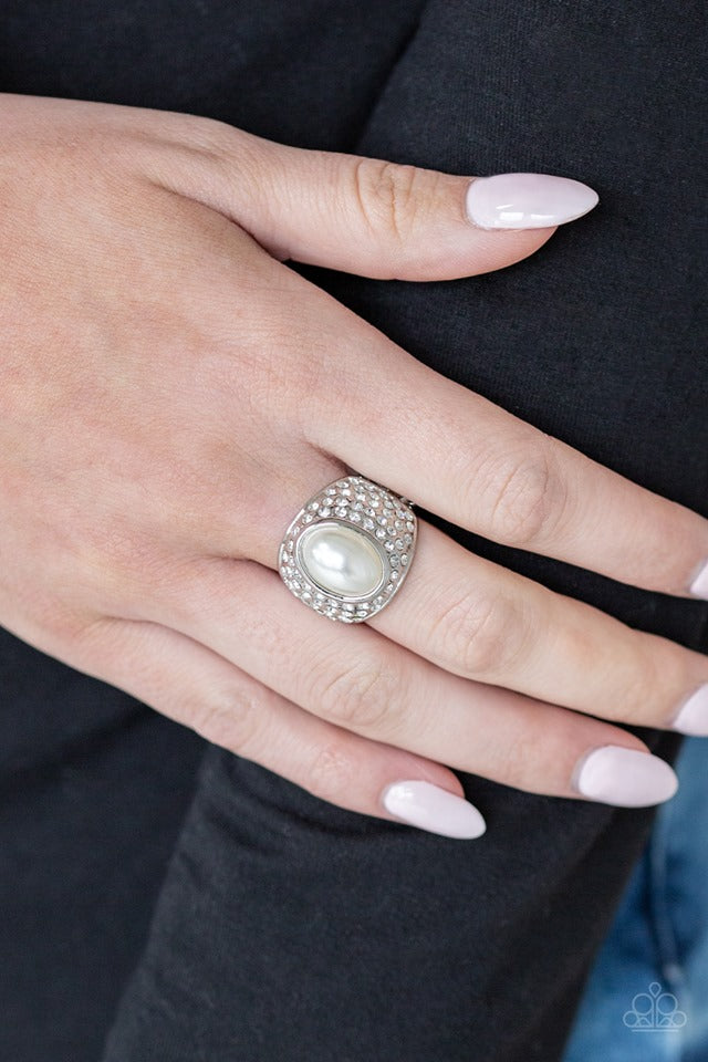 A pearly white bead is pressed into the center of a bold silver band radiating with countless white rhinestones, creating a dramatic statement piece atop the finger. Features a stretchy band for a flexible fit.  Sold as one individual ring.  Always nickel and lead free.  Life of the Party 