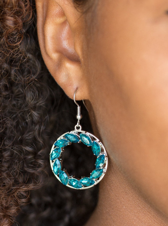 Featuring regal marquise style cuts, glittery blue rhinestones are encrusted along a shimmery silver hoop for a radiant fashion. Earring attaches to a standard fishhook fitting.  Sold as one pair of earrings. 