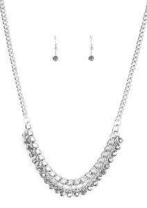 A fringe of glittery hematite rhinestones swings from the bottom of a bold silver chain below the collar for a fierce look. Features an adjustable clasp closure.  Sold as one individual necklace. Includes one pair of matching earrings.  