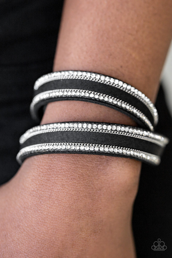 An elongated black suede band is encrusted in rows of glassy white rhinestones and shimmery silver chains. The elongated band double wraps around the wrist for a fierce one-of-a-kind look. Features an adjustable snap closure.  Sold as one individual bracelet.   Always nickel and lead free.