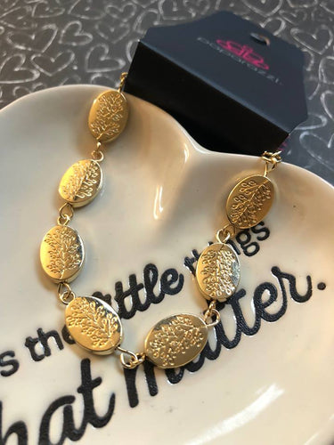 Stamped in a leafy tree pattern, shiny gold beads link around the wrist in a whimsical fashion. Features an adjustable clasp closure.  Sold as one individual bracelet.