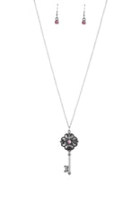 Load image into Gallery viewer, Dotted with a glittery pink rhinestone, a vintage inspired key pendant swings from the bottom of an elegantly elongated silver chain for a whimsical look. Features an adjustable clasp closure.  Sold as one individual necklace. Includes one pair of matching earrings.