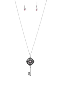 Dotted with a glittery pink rhinestone, a vintage inspired key pendant swings from the bottom of an elegantly elongated silver chain for a whimsical look. Features an adjustable clasp closure.  Sold as one individual necklace. Includes one pair of matching earrings.