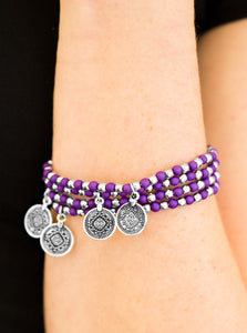 Dainty purple and silver beads are threaded along stretchy elastic bands, creating colorful layers across the wrist. Brushed in an antiqued shimmer, ornate silver charms swing from the wrist for a wanderlust finish.  Sold as one set of four bracelets.