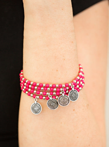 Dainty pink and silver beads are threaded along stretchy elastic bands, creating colorful layers across the wrist. Brushed in an antiqued shimmer, ornate silver charms swing from the wrist for a wanderlust finish.  Sold as one set of four bracelets.