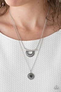 Radiating with linear patterns, a shimmery silver frame swings from the uppermost chain above a silver disc radiating with floral detail. A dainty black bead dots the center of the lowermost pendant for a colorful finish. Features an adjustable clasp closure.  Sold as one individual necklace. Includes one pair of matching earrings.  Always nickel and lead free.