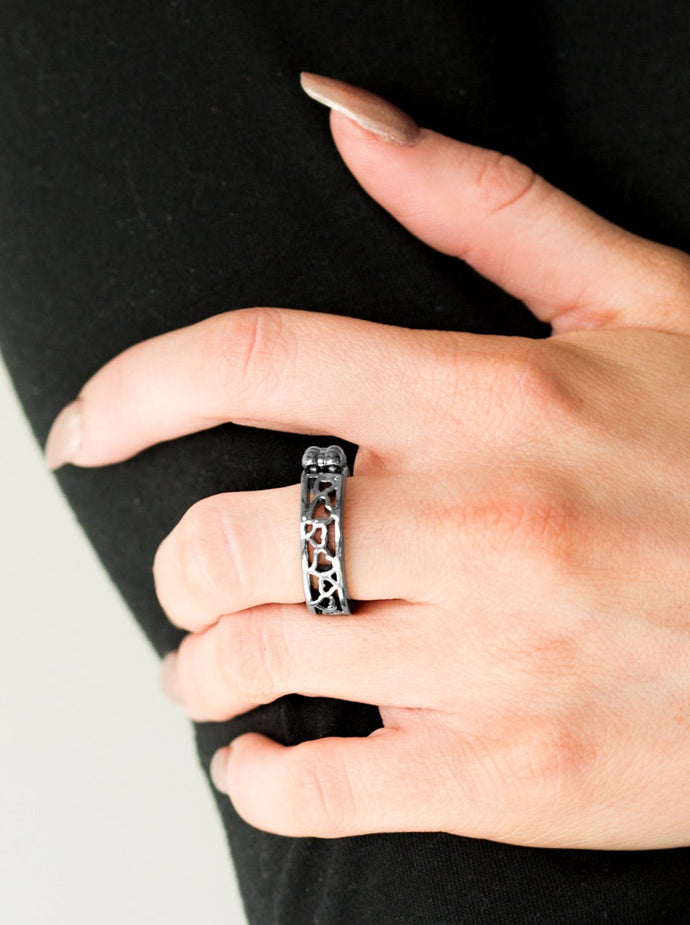 Dainty gunmetal heart silhouettes connect down the center of a shimmery gunmetal band, creating an airy frame. Features a dainty stretchy band for a flexible fit.  Sold as one individual ring.  