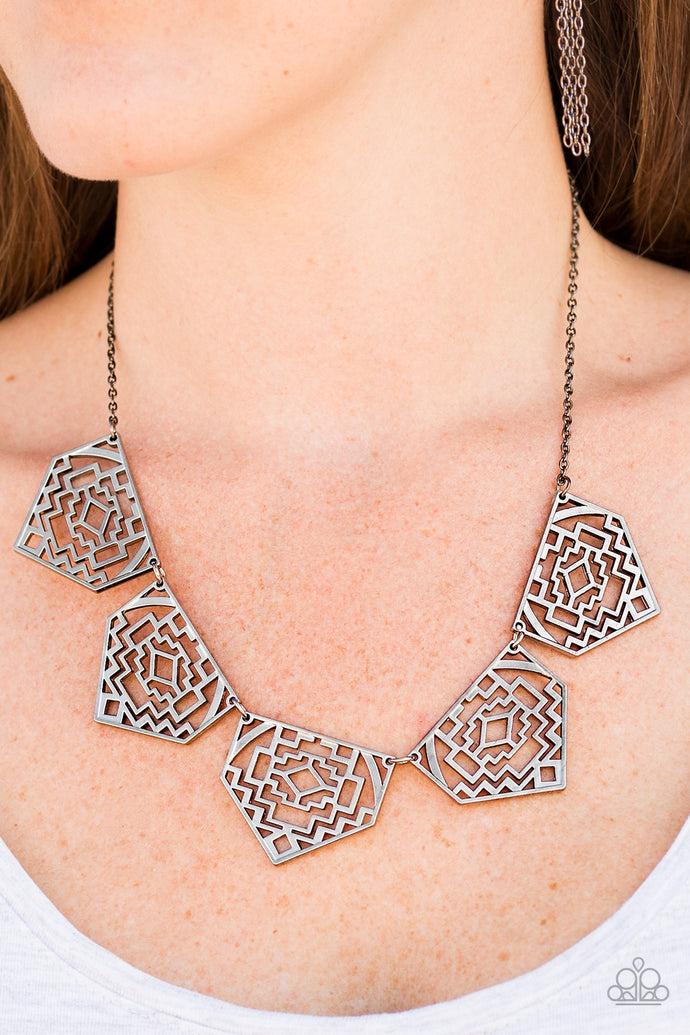 Shimmery metallic plates swing from a classic gunmetal chain, creating a geometric fringe. Decorated in a Southwestern textile pattern, the stenciled plates fall just below the collar in an airy fashion. Features an adjustable clasp closure.  Sold as one individual necklace. Includes one pair of matching earrings.  Always nickel and lead free.