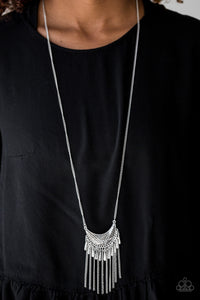 Radiating in linear textures, a glistening silver crescent swings from the bottom of a lengthened silver chain. Shimmery silver chains and flared silver beading swings from the bottom of the tribal inspired pendant, creating a flirtatious fringe. Features an adjustable clasp closure.  Sold as one individual necklace. Includes one pair of matching earrings.  Always nickel and lead free.