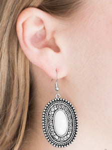 A neutral white bead is pressed into a shimmery silver frame embossed in studded and spiral detail for a seasonal look. Earring attaches to a standard fishhook fitting.  Sold as one pair of earrings. 