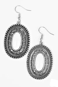 A neutral white bead is pressed into a shimmery silver frame embossed in studded and spiral detail for a seasonal look. Earring attaches to a standard fishhook fitting.  Sold as one pair of earrings.