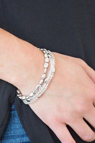 Infused with hints of silver, dainty white crystal-like beads are threaded along stretchy bands, creating whimsical layers across the wrist.  Sold as one set of three bracelets.  Always nickel and lead free