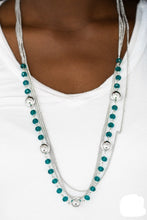 Load image into Gallery viewer, Infused with rows of shimmery silver chains, a strand of glittery blue crystal-like beads and classic silver accents drape across the chest for a regal finish. Features an adjustable clasp closure.  Sold as one individual necklace. Includes one pair of matching earrings.
