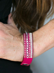 Shiny gold studs, silver chain, and rows of dazzling white rhinestones adorn strands of pink suede, creating endless shimmer across the wrist. Features an adjustable snap closure.  Sold as one individual bracelet.