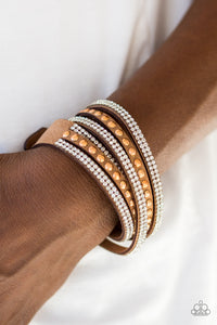 Rows of glassy white rhinestones and glistening copper studs are pressed along three strands of brown suede for a sassy look. The elongated band allows for a trendy double wrap design. Features an adjustable snap closure.  Sold as one individual bracelet.  Always nickel and lead free.