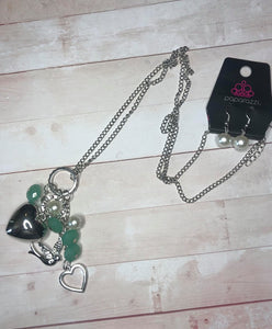 A silver bird charm, silver heart charms, and collection of white pearls and opaque green  crystal-like beads swing from the bottom of a lengthened silver chain for a whimsically clustered look. Features an adjustable clasp closure.  Sold as one individual necklace. Includes one pair of matching earrings.  Exclusive!