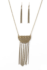 Embossed in radiating sunburst patterns, a tribal inspired pendant swings from the bottom of a glistening brass chain for a seasonal look. Dainty brass chains stream from the bottom of the crescent-shaped pendant, adding a wanderlust vibe to the indigenous look. Features an adjustable clasp closure.  Sold as one individual necklace. Includes one pair of matching earrings.