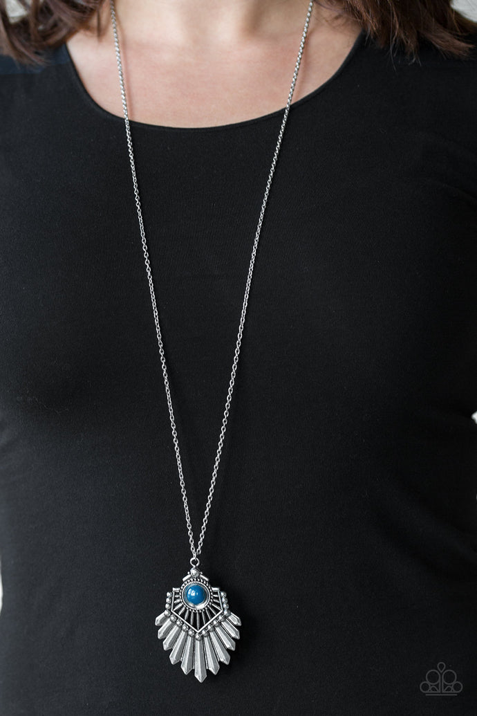 Infused with a lengthened silver chain, a polished blue bead is pressed into the center of a flared silver pendant for a bold tribal flair. Features an adjustable clasp closure.  Sold as one individual necklace. Includes one pair of matching earrings  Always nickel and lead free.