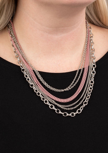 Painted in a colorful finish, shiny pink chains join a collision of silver chains below the collar for a daring industrial look. Features an adjustable clasp closure.  Sold as one individual necklace. Includes one pair of matching earrings.  