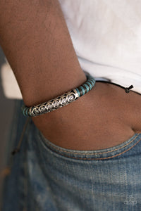 Blue and black cording knots around a leather cord, creating a colorful urban piece around the wrist. An ornate silver bead slides along the colorful strand, creating a bold centerpiece. Features an adjustable sliding knot closure.  Sold as one individual bracelet.  Always nickel and lead free.