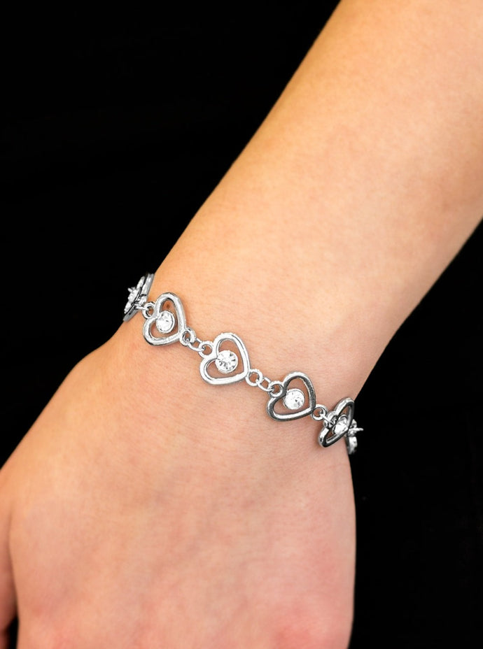 Glittery white rhinestones are pressed into the centers of shimmery silver hearts. The glistening silver hearts link across the wrist in a whimsical fashion. Features an adjustable clasp closure.  Sold as one individual bracelet.