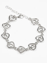 Load image into Gallery viewer, Glittery white rhinestones are pressed into the centers of shimmery silver hearts. The glistening silver hearts link across the wrist in a whimsical fashion. Features an adjustable clasp closure.  Sold as one individual bracelet.