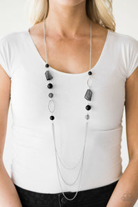 Faceted black jewels and polished black beads trickle along a shimmery silver chain for a seasonal look. Infused with shiny silver hoops, the colorful beading gives way to layers of chain for a whimsical finish. Features an adjustable clasp closure.