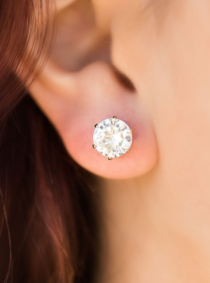 A sparkling white rhinestone is nestled inside a classic gold frame for a timeless look. Earring attaches to a standard post fitting.  Sold as one pair of post earrings.   