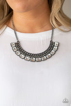 Load image into Gallery viewer, Stationary rows of shimmery gunmetal chain, glittery hematite rhinestones, and glassy white emerald-cut gems coalesce into a bold pendant below the collar. Features an adjustable clasp closure.  Sold as one individual necklace. Includes one pair of matching earrings. Always nickel and lead free.