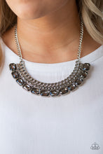 Load image into Gallery viewer, Stationary rows of shimmery silver chain, glittery hematite rhinestones, and smoky emerald-cut gems coalesce into a bold pendant below the collar. Features an adjustable clasp closure.  Sold as one individual necklace. Includes one pair of matching earrings. Always nickel and lead free.